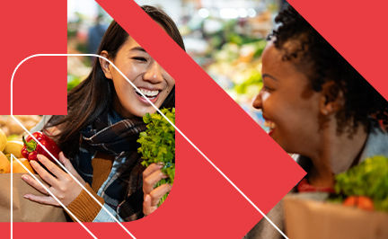 Precision Nutrition Level 1 Coach, discussing nutrition with a client while standing around vegetables in a grocery store