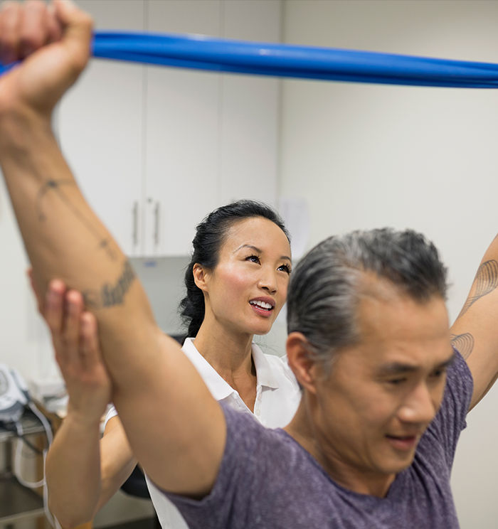 ACE Functional Training Specialist leading client through corrective band exercise in a rehab-like environment