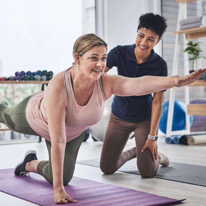 ACE Pain-Free Movement Specialist guiding a client through the proper form for a balancing exercise
